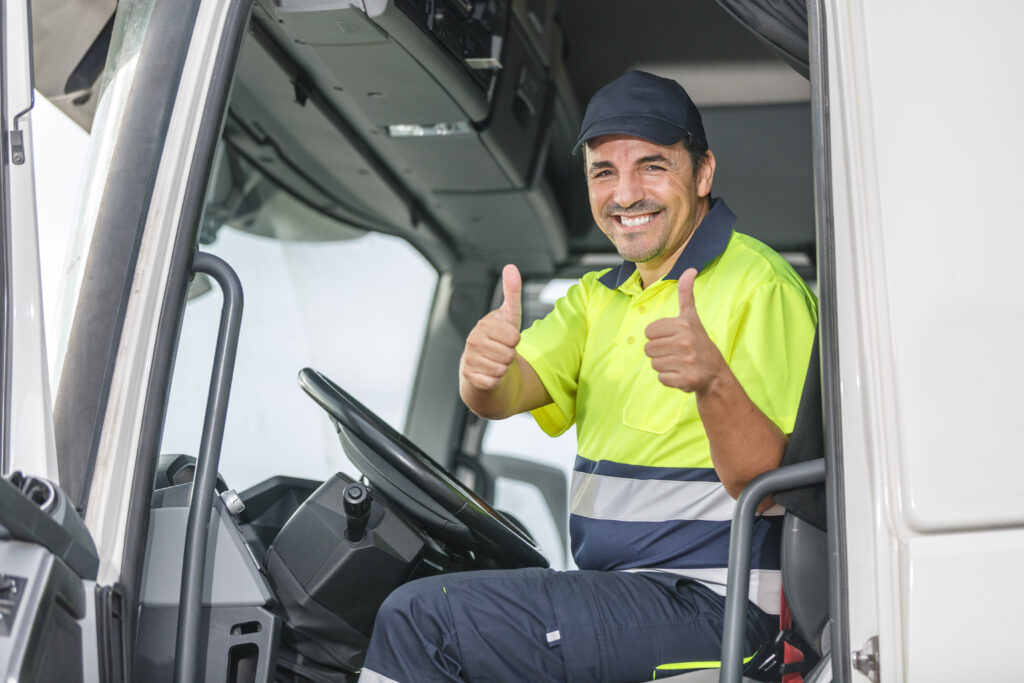Smiling driver in safety cloth showing double approval with thumbs up